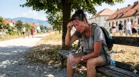 Oseba trpi zaradi vrocine in dehidracije v poletni susi v Sloveniji.