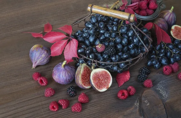 Black grapes in a basket and ripe figs, red raspberries and blackberries with autumn leaves on the wooden background,Image: 1022954034, License: Royalty-free, Restrictions:, Model Release: no, Credit line: Tatiana Epifanova/imageBROKER/Profimedia