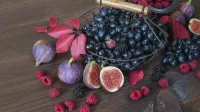 Black grapes in a basket and ripe figs, red raspberries and blackberries with autumn leaves on the wooden background,Image: 1022954034, License: Royalty-free, Restrictions:, Model Release: no, Credit line: Tatiana Epifanova/imageBROKER/Profimedia
