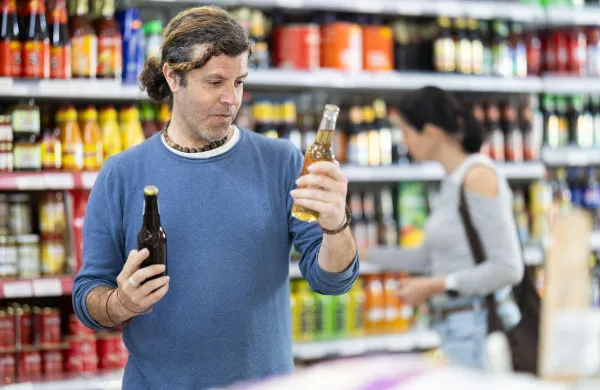 Adult man buyer chooses beer in bottle in grocery store,Image: 1090819492, License: Royalty-free, Restrictions:, Model Release: no, Credit line: Iakov Filimonov/Alamy/Profimedia
