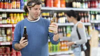 Adult man buyer chooses beer in bottle in grocery store,Image: 1090819492, License: Royalty-free, Restrictions:, Model Release: no, Credit line: Iakov Filimonov/Alamy/Profimedia
