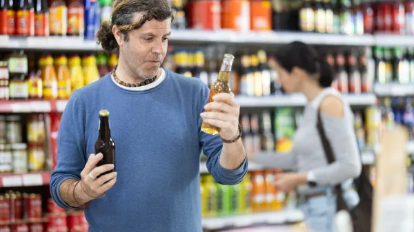 Adult man buyer chooses beer in bottle in grocery store,Image: 1090819492, License: Royalty-free, Restrictions:, Model Release: no, Credit line: Iakov Filimonov/Alamy/Profimedia