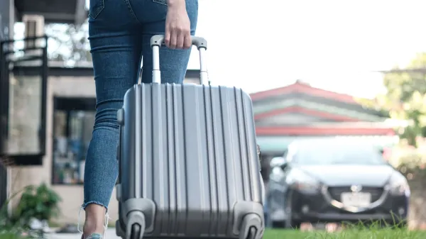 Traveler woman carrying luggage. Tourist walking with Suitcases Travel lifestyle concept