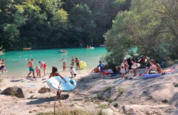 Ob rekah je množica kopalcev z najrazličnej&scaron;imi plovnimi pripomočki. 