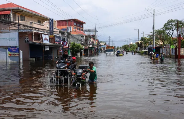 PAMPANGA, PHILIPPINES - AUGUST 20: People wade through a flooded road due to monsoon rains, in Apalit, Pampanga, Philippines, on August 20, 2026. The lingering monsoon effects, compounded with the intensifying tropical storm Saudel that is expected to turn into a typhoon, have recently brought humongous rains to the Philippines, causing widespread, serious flooding in multiple areas across 10 different regions, including those on Central Luzon. As a result, tens of thousands of people across the Southeast Asian country have been displaced or evacuated to safety. Daniel Ceng/Anadolu,Image: 1126129734, License: Rights-managed, Restrictions:, Model Release: no, Credit line: Daniel Ceng/AFP/Profimedia