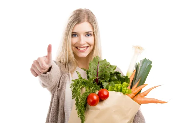 Beautiful blonde woman carrying a bag full of vegetables with thumbs up, isolated over white background,Image: 1131820510, License: Royalty-free, Restrictions:, Model Release: no, Credit line: -/Ingram/Profimedia