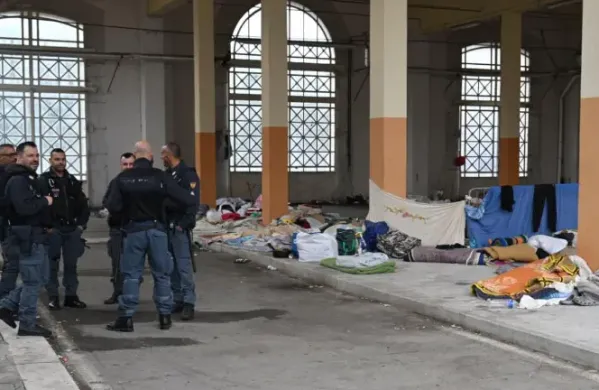 Policija ob monumentalnem vhodu, kjer so bivakirali migranti 