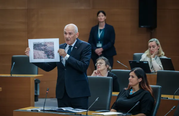 Predsednik vlade Janez Jan&scaron;a kaže fotografije žrtev v Sudanu.