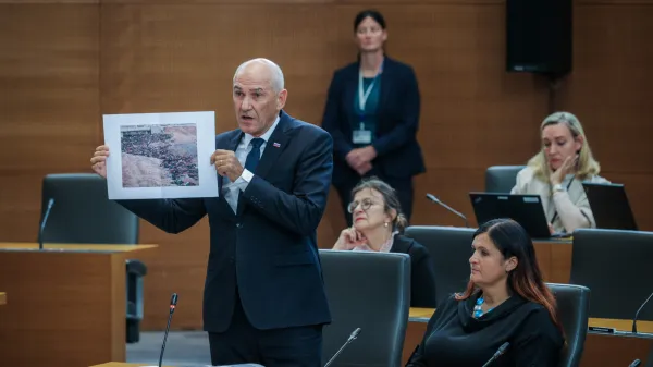 Predsednik vlade Janez Jan&scaron;a kaže fotografije žrtev v Sudanu.