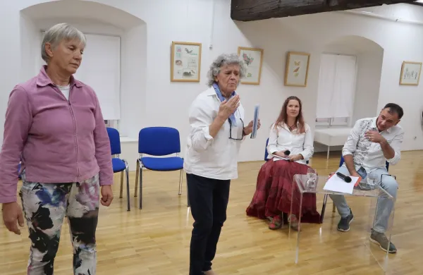 Kulturni zamejki - Alenka Petaros in Neva Hussu - v dveh narečjih o življenju v trža&scaron;kih vaseh nekoč. V ozadju voditelja narečnega večera Silva Mlekuž in David Velikanje.