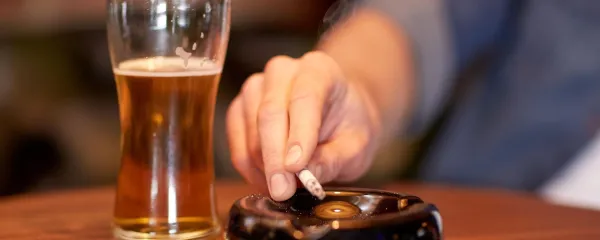 people, smoking, nicotine addiction and bad habits concept - close up of male hand with beer shaking cigarette ashes to ashtray at bar or pub,Image: 313493944, License: Royalty-free, Restrictions:, Model Release: yes, Credit line: Lev Dolgachov/Alamy/Profimedia
