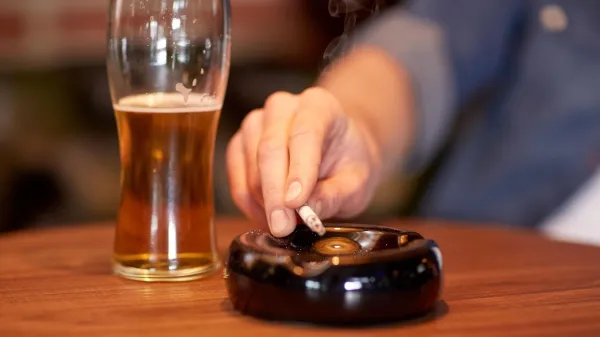 people, smoking, nicotine addiction and bad habits concept - close up of male hand with beer shaking cigarette ashes to ashtray at bar or pub,Image: 313493944, License: Royalty-free, Restrictions:, Model Release: yes, Credit line: Lev Dolgachov/Alamy/Profimedia